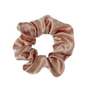 Elegant satin silk scrunchie in champagne gold with premium metallic luster and soft folds