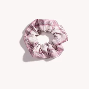 Dettaglio dell'elastico scrunchie a quadretti rosa con tessuto morbido e design plissettato