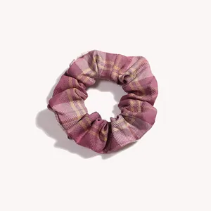 Vista dettagliata di un elastico scrunchie a quadri viola con motivo vintage e trama morbida