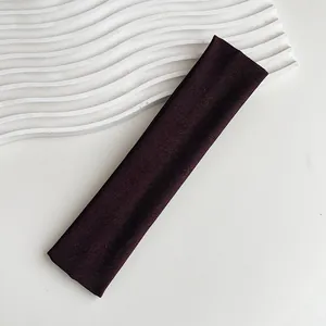 Dettaglio ravvicinato della trama della fascia elastica in maglia marrone scuro su bianco