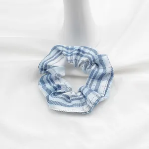 Dettaglio di un elastico per capelli a scacchi blu e bianchi su base di ceramica