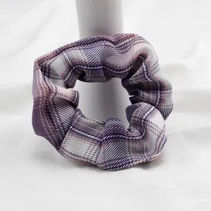 Dettaglio dell'elastico scrunchie a quadri viola con trama in cotone e pieghe elastiche
