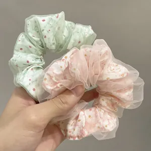 Detail of green and pink double-layered mesh scrunchies with floral inner patterns