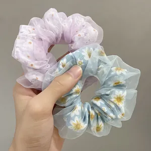 Detail of light purple polka dot and light blue daisy double-layered mesh scrunchies