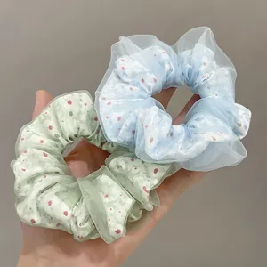 Detail of light green and blue double-layer mesh scrunchies with red polka dot pattern