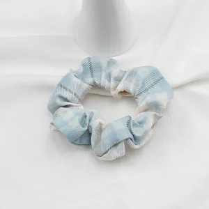 Dettaglio dell'elastico scrunchie a quadri azzurro e bianco in tessuto twill morbido