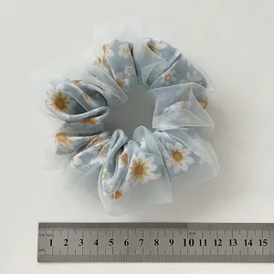 Detail of light blue double-layered daisy scrunchie with sheer organza outer layer