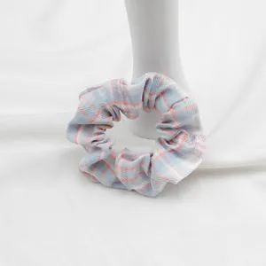 Vista dettagliata di un elastico per capelli a scacchi blu e rosa con trama pieghettata