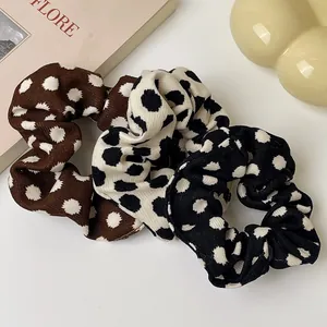 Set of 3 polka dot scrunchies in brown, cream, and black textured fabric accessories