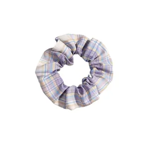 Elastico per capelli a quadretti viola, blu e beige su sfondo bianco pulito
