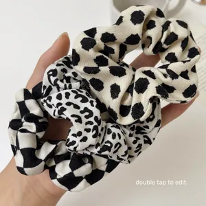 Close-up of knitted leopard print and checkerboard hair scrunchies with soft fabric texture