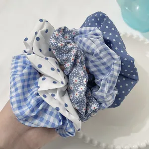 Close-up of blue and white polka dot scrunchies in various fabric patterns and textures