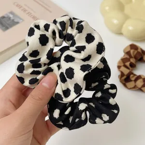 Close-up of fabric scrunchies with polka dot and checkered patterns in a cozy setting