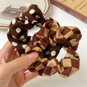 Close-up of polka dot and checkered fabric scrunchies with soft pleated texture