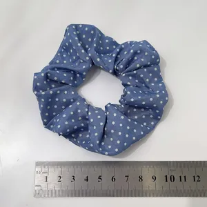 Detailed view of ocean blue polka dot scrunchie fabric with a measuring scale