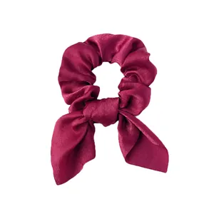 Vue détaillée du chouchou en satin bordeaux foncé avec des nœuds en oreilles de lapin