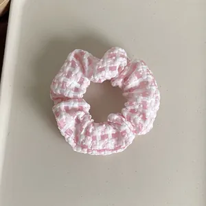 Close-up of pink and white checkered scrunchie with seersucker textured fabric