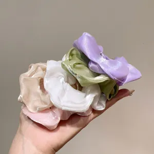Cinque elastici in organza in vari colori pastello su uno sfondo grigio pulito