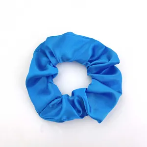 Top-down view of royal blue satin scrunchie showing smooth texture and elegant folds