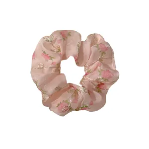 Pink floral organza scrunchie with rose patterns and gold thread embroidery on white backdrop