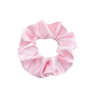 Pink satin scrunchie with glossy silk texture for elegant women hair styling