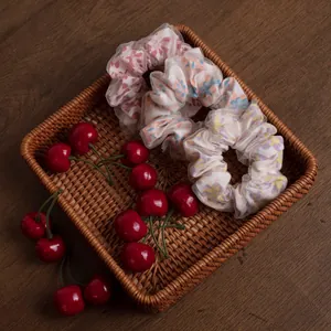 Nahaufnahme von Organza-Haargummis mit Blumenmuster in einem geflochtenen Korb