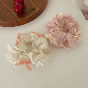 Pastel organza bow scrunchies in cream and pink colors with delicate ribbon accents