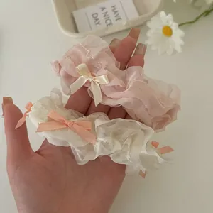 Pink and creamy white bow scrunchies made of airy organza on a minimalist desk set