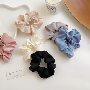 Set aus sechs farbenfrohen Satin-Haargummis in Pastelltönen auf weißem Hintergrund