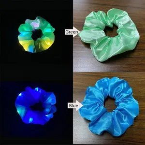 Detailweergave van groene en blauwe LED satijnen scrunchies met lichtgevend effect
