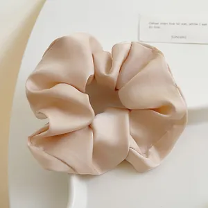 Makroaufnahme von elegantem Champagner-Satin-Haargummi mit weichen Stofffalten