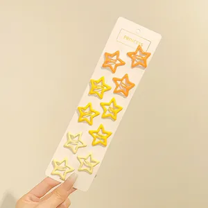 Primer plano de diez pinzas para el pelo con forma de estrella amarilla en tarjeta blanca