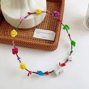 Close-up of colorful LED floral headband with roses and berries in a woven basket