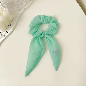 Detail von minzgrünem LED-Haargummi mit Schleife aus transparentem Organza-Stoff