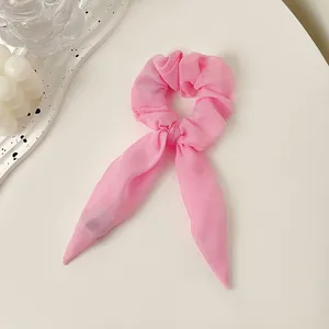 Detailaufnahme eines rosa Chiffon-Haargummis mit langen Hasenohren auf weißem Grund