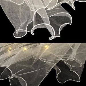 Gros plan détaillé du voile en tulle blanc avec lumières LED chaudes et bords ondulés