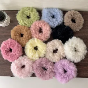 Macro shot of fluffy plush hair scrunchies in various candy colors on wood background