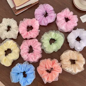 Lot de chouchous LED en résille aux couleurs macaron variées sur un bureau en bois