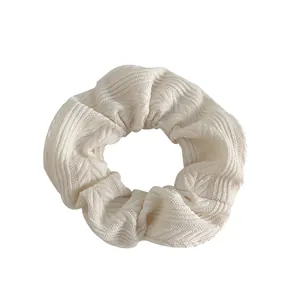 Knitted cream oversized scrunchie with soft ribbed texture for elegant ponytail hair styling