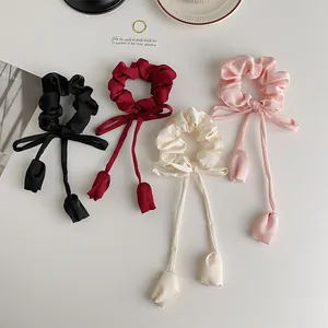 Elegant satin scrunchies with long ribbons in four colors shown on a minimalist background