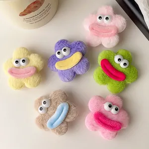 Détail de pinces à cheveux fleurs en peluche aux grands yeux et lèvres épaisses colorées