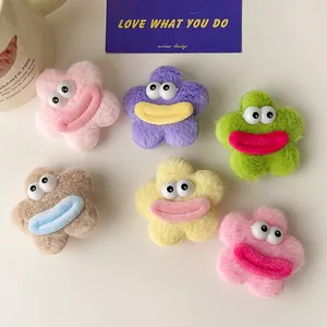 Détail des barrettes fleurs en peluche avec de grands yeux et des lèvres rigolotes