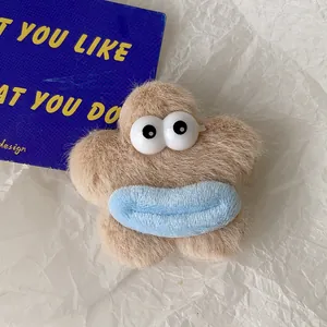 Détail d'une pince à cheveux étoile en peluche avec grands yeux et lèvres bleues