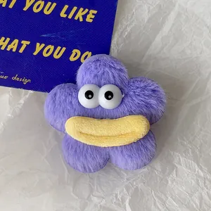 Détail macro d'une pince à cheveux fleur en peluche violette avec de grands yeux