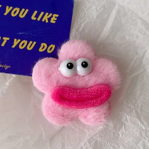 Vue détaillée d'une broche en peluche rose avec de grands yeux et des lèvres charnues