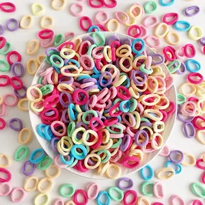 Close-up of assorted candy-colored high-elasticity hair ties for kids in a white plate