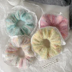 Detailed close-up of knitted scrunchies with white lace trim and pearl accents in pastel colors