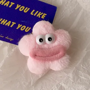 Détail de la pince à cheveux étoile en peluche rose avec grands yeux et lèvres