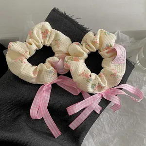Blumiges Waffelstoff-Haargummi-Set mit rosa karierten Schleifen auf dunklem Hintergrund