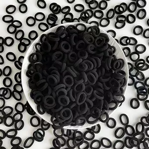 Close-up of black seamless elastic hair ties in a white ceramic bowl for children
